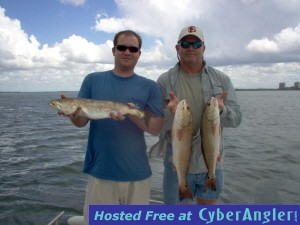 pair of redfish and a 23 inch trout