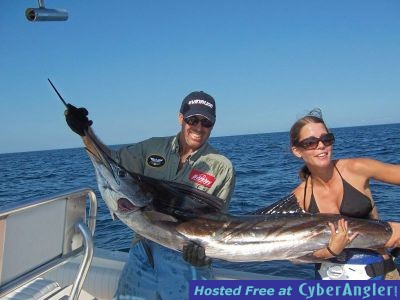 Sarah displays her catch as dad gives a hand